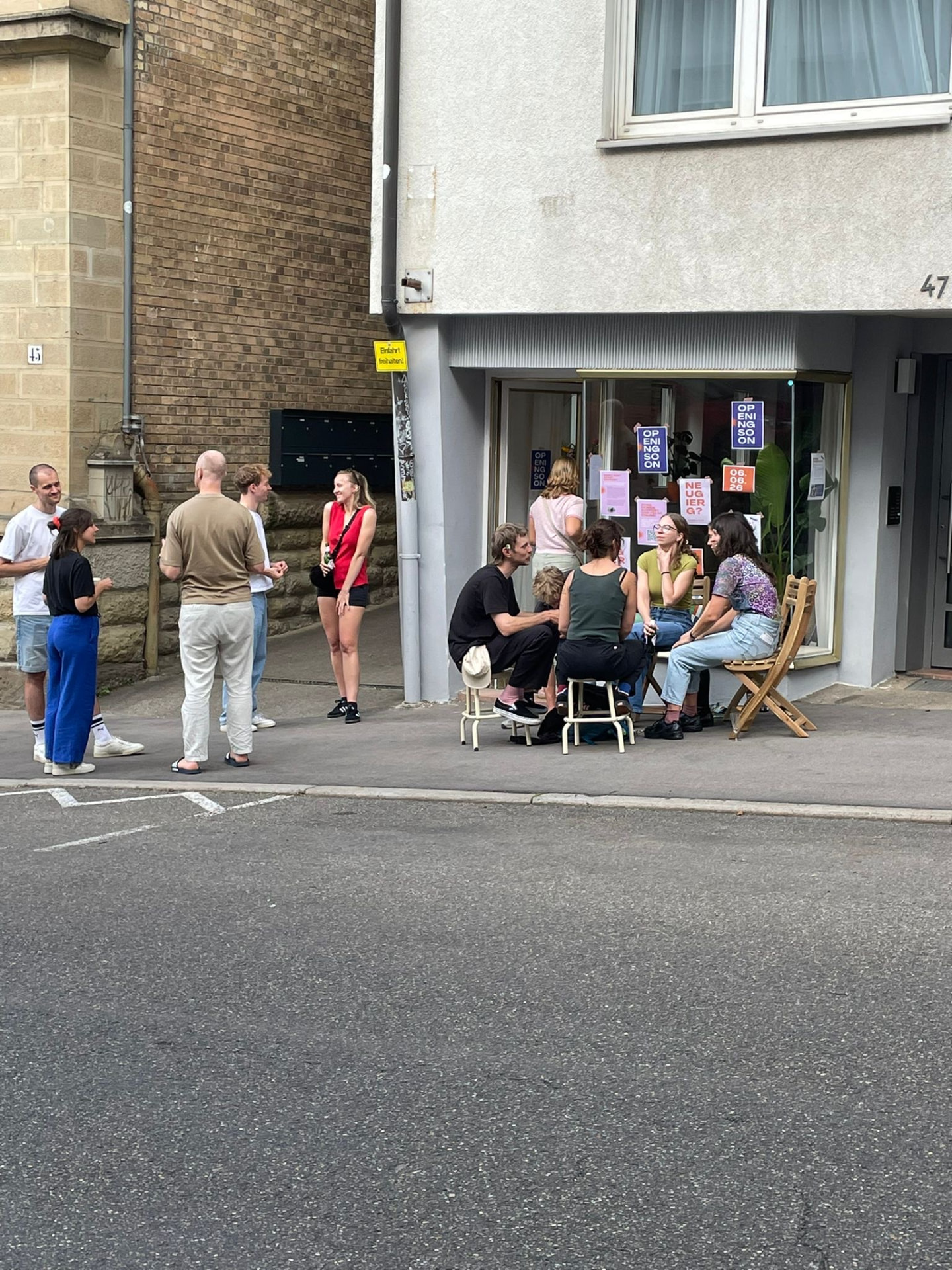 Menschen sitzen und stehen vor dem Studio in der Kernerstraße 47, Stuttgart